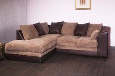 a brown couch sitting on top of a hard wood floor next to a white wall