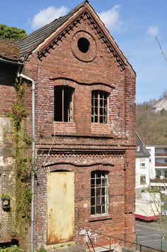 an old red brick building with broken windows