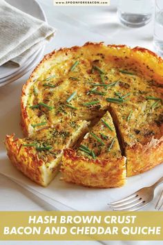 a quiche on a plate with a fork and glass of water in the background