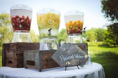 a table topped with lots of different types of liquid in glass containers and wooden crates