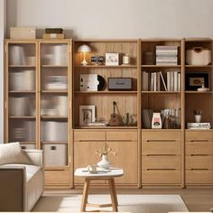 a living room filled with lots of furniture and bookshelves next to a white couch