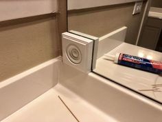 an electronic device sitting on top of a counter next to a tube of toothpaste