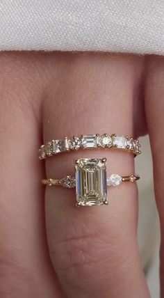 a woman's hand with an engagement ring and wedding band