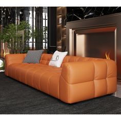 an orange leather couch sitting in front of a fire place with pillows on top of it