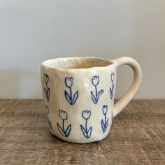 a blue and white coffee cup sitting on top of a wooden table