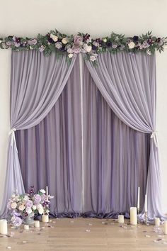 the wedding stage is decorated with purple flowers and greenery for an elegant touch to the venue