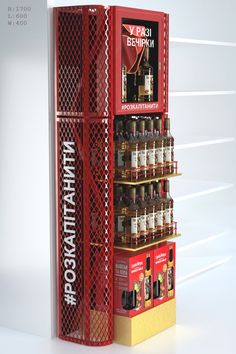 a red and yellow display case filled with lots of bottles