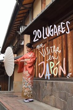 a woman holding an umbrella standing in front of a sign that reads 20 lugares ave vistar en daron