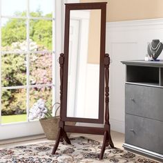 a large mirror sitting on top of a wooden floor next to a dresser and window