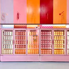 an ice cream shop with pink, orange and yellow stripes on the wall behind it