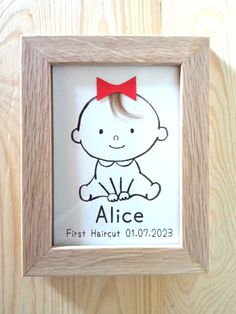 a wooden frame with a drawing of a baby's face in the shape of a red bow