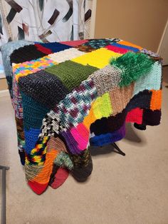 a multicolored afghan sitting on top of a chair