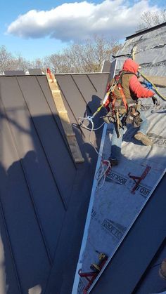 a man is working on the roof of a house with a rope attached to it