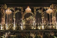 an elaborately decorated stage with chandeliers and greenery