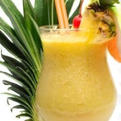 a pineapple and orange smoothie is garnished with fresh fruit