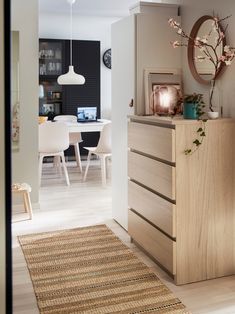 a room with a dresser, table and chairs