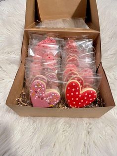 a box filled with lots of pink and red heart shaped cookies next to each other