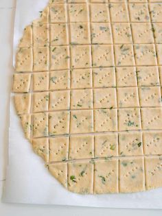 crackers are laid out on a piece of parchment paper to be used as an appetizer