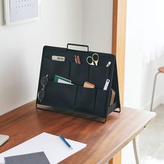 a desk with a laptop, pen and glasses sitting on top of it next to a folder