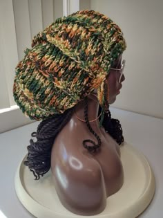 a mannequin wearing a knitted hat with braids on it's head