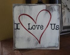 a wooden sign that says i love us with a heart painted on it