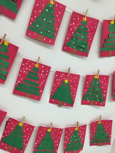 christmas cards are hung on clothes pins with green and red trees hanging from the clothes pegs