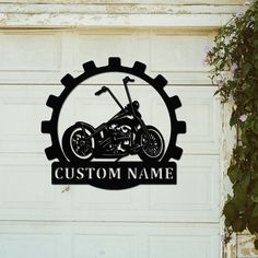 a custom motorcycle logo on the side of a garage door with flowers growing around it