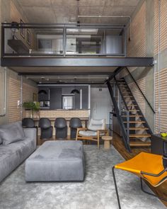 a living room filled with furniture next to a stair case in a loft style home