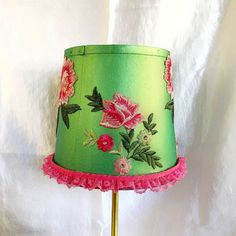 a green lamp shade with pink flowers on it