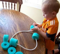 a young boy is playing with toys on the table