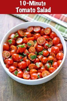 a bowl filled with cherry tomatoes on top of a wooden table