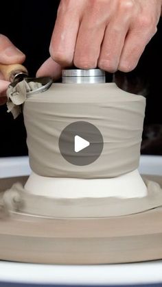 a person is making a vase out of clay with a wheel on the side and one hand