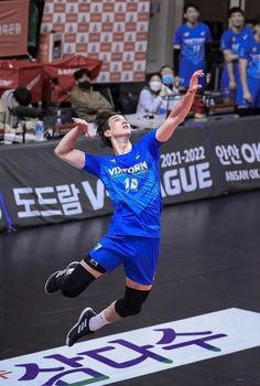 a man jumping up in the air to catch a frisbee on a court