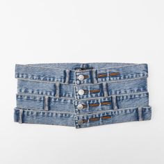 three pairs of blue jean shorts with buttons on the side and one pair in front