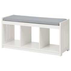 a white bench with a cushion on it's seat and two shelves for storage