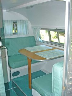 the inside of a camper with a table and chairs