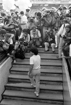 black and white photograph of people on stairs with cameras