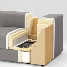 an open box sitting on top of a couch next to a table with drawers in it