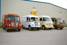 three vans are parked next to each other in front of a building