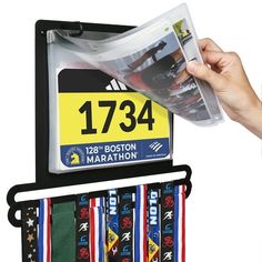 a person holding up a marathon medal holder