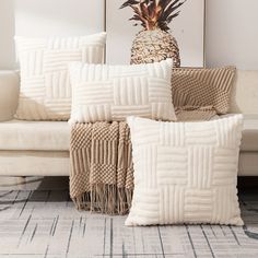 three pillows on a couch with a pineapple in the middle and another pillow behind it