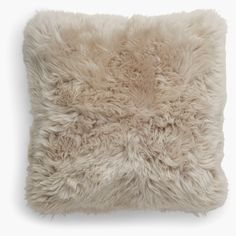 a white pillow with fluffy fur on it