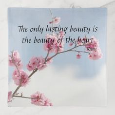 a pink flower on a branch with a quote about the beauty of the heart above it