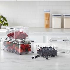 three plastic containers filled with fruit on top of a kitchen counter