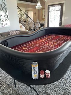 a game table with two cans of beer and some dice on the floor next to it