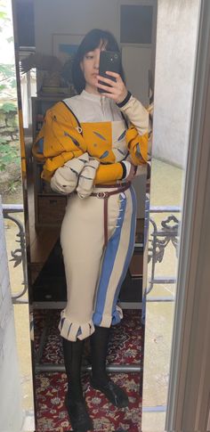 a woman is taking a selfie in the mirror while wearing a dress and boots