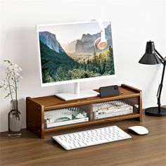 a computer monitor sitting on top of a wooden desk next to a keyboard and mouse