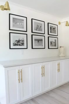 white cabinets with pictures on the wall above them