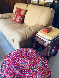 a living room with a couch, ottoman and coffee table in front of bookshelves