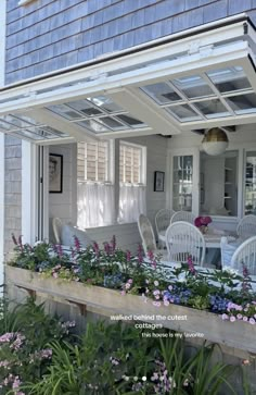 the front porch is filled with flowers and chairs